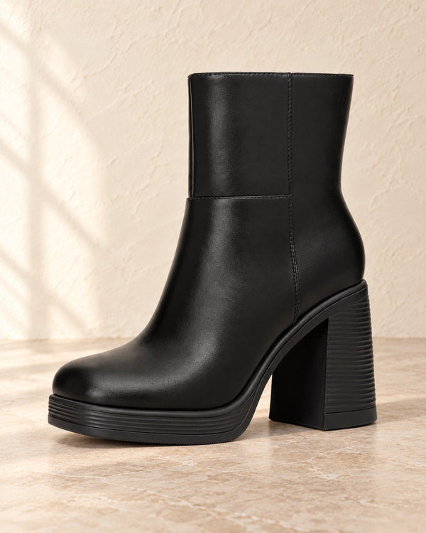Black platform ankle boot on warm cream plaster and pale stone studio background